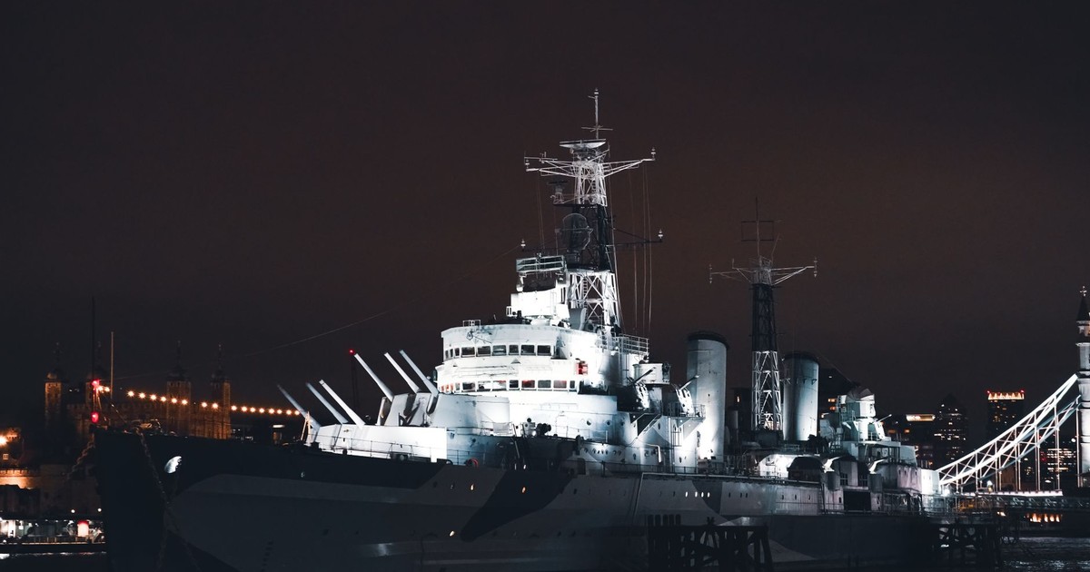 A stunning night view of HMS Belfast illuminated on the River Thames in London, United Kingdom.