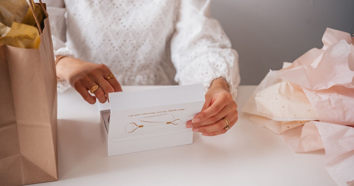 Woman with rings opening a jewelry gift box, emphasizing elegance and anticipation.
