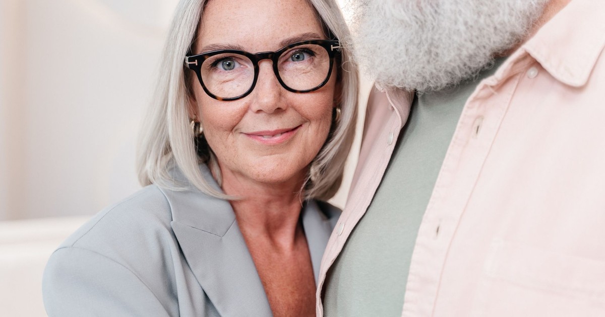 Close-up of a smiling senior woman wearing eyeglasses indoors.
