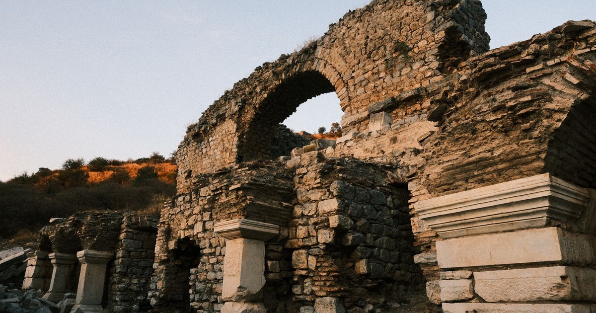 The image captures ancient stone ruins with arches, evoking a sense of history and exploration.