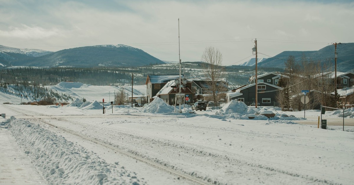 A tranquil snowy landscape featuring a small mountain town in Colorado during wintertime.