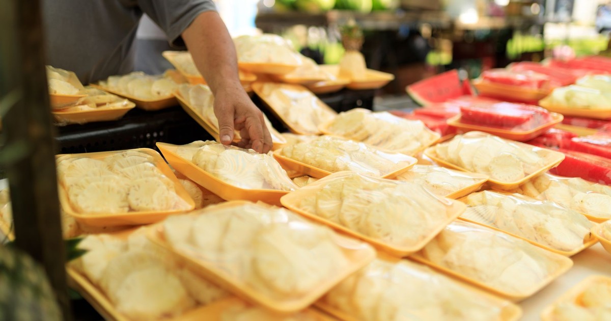 A person picking fresh packaged food at an outdoor market.