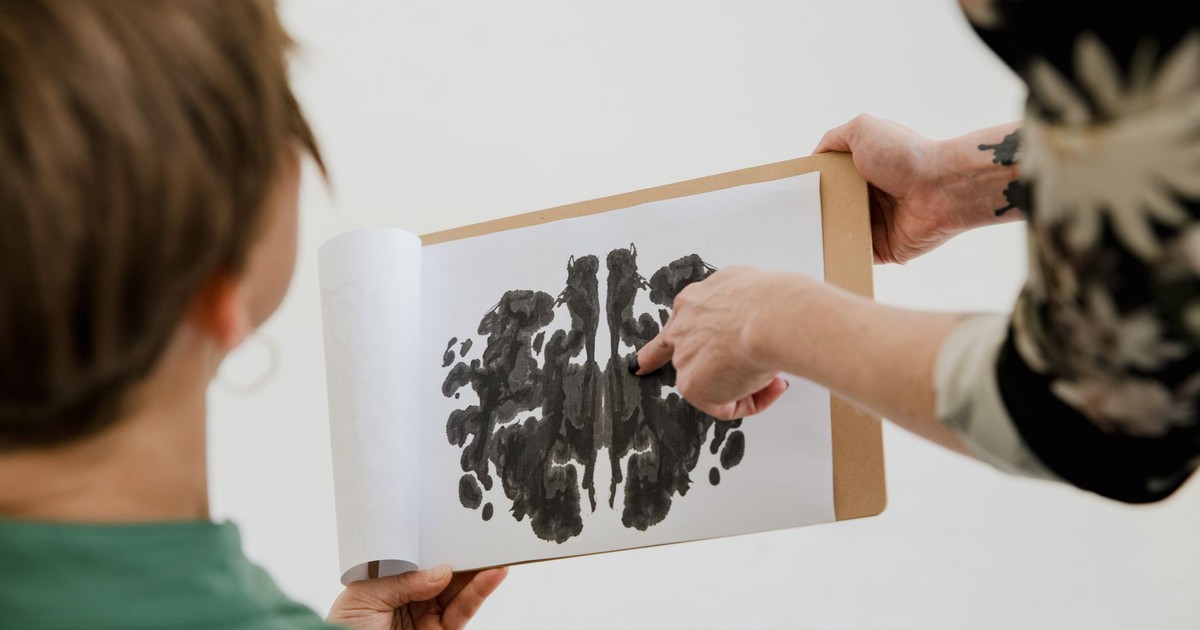 A psychologist and patient discuss a Rorschach inkblot test during a therapy session.
