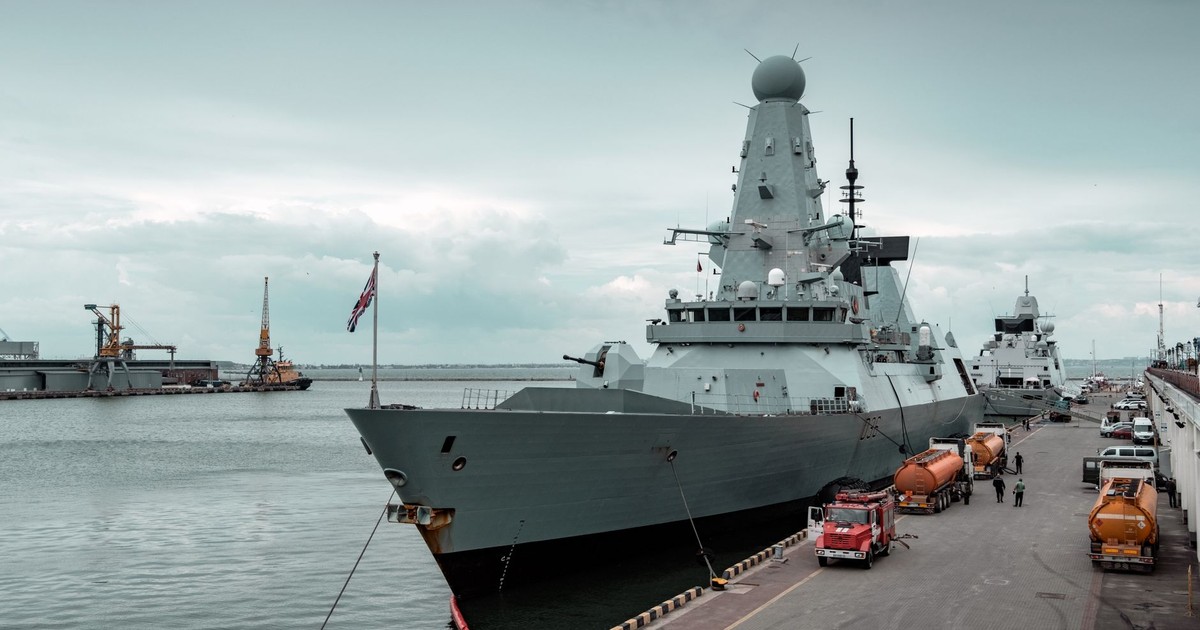 A navy destroyer docked at Odesa harbor with cloudy sky, highlighting maritime defense.