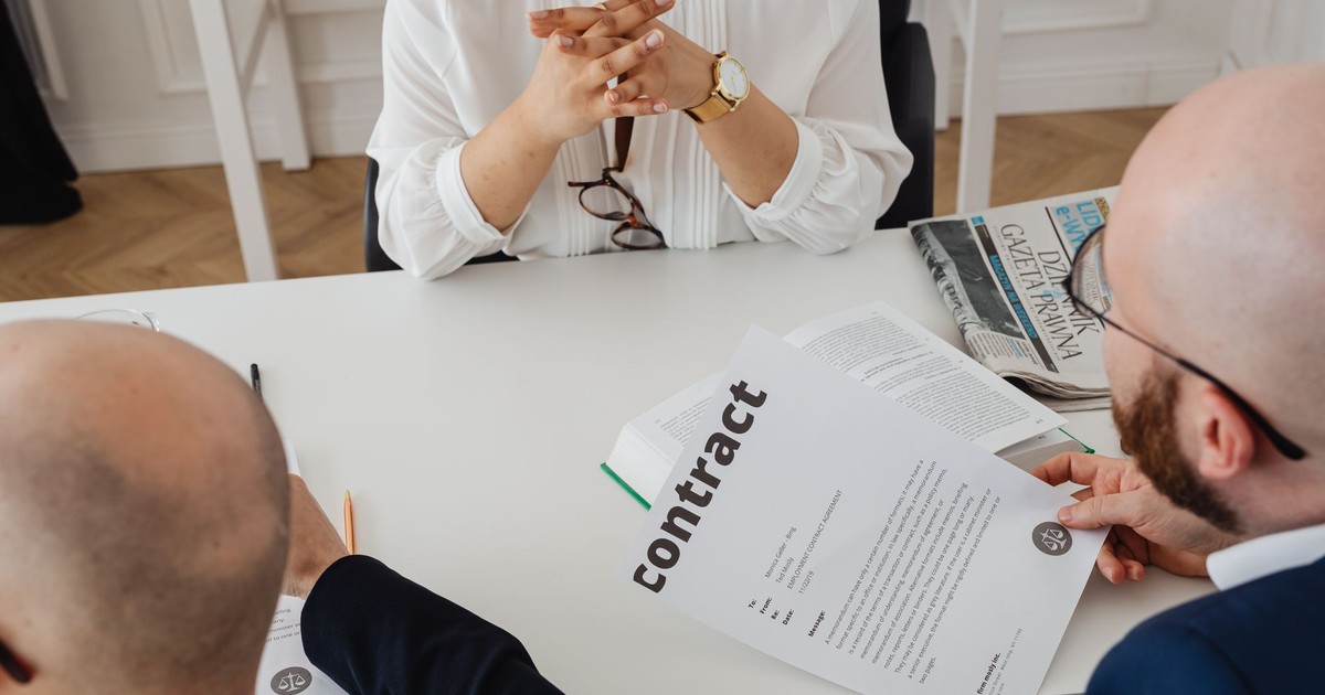 Business professionals discussing a contract in a modern office setting.