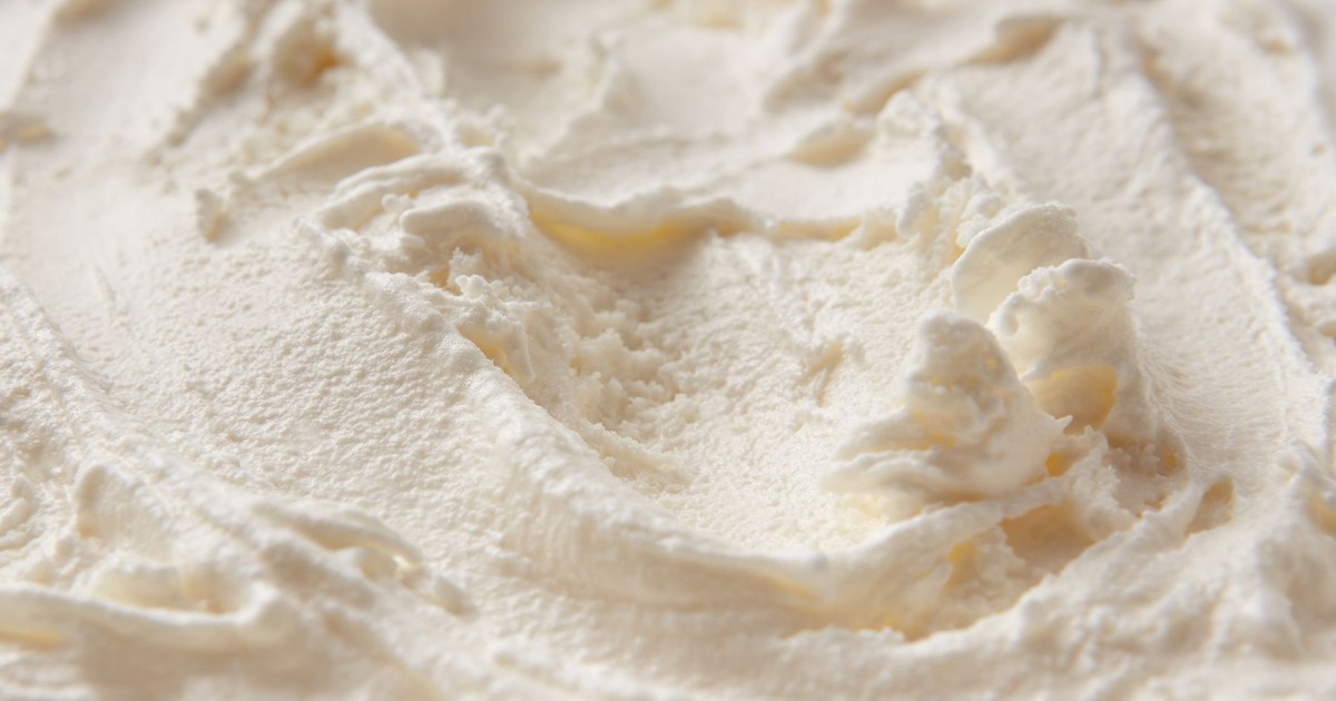 Detailed close-up of creamy white ice cream texture, highlighting its smooth and soft consistency.