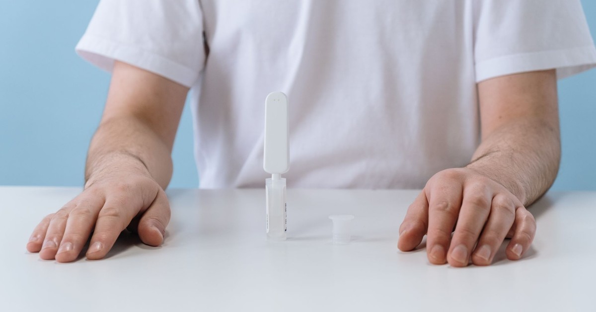 A person conducting an HIV test using an OraQuick kit, emphasizing home health diagnostics.
