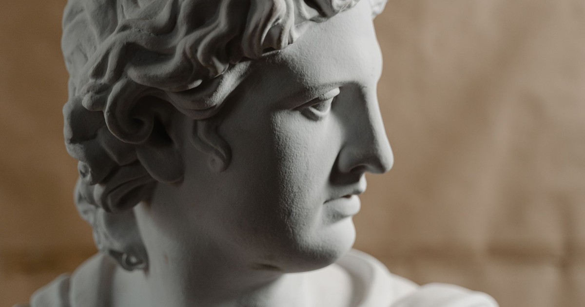 Close-up of a classical marble bust on a soft brown background, artistic lighting.