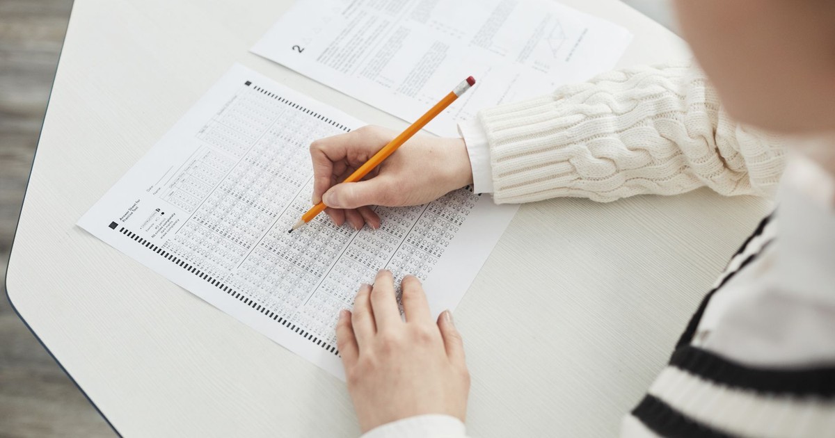 Close-up of a student filling out a multiple-choice exam in a quiet classroom setting.