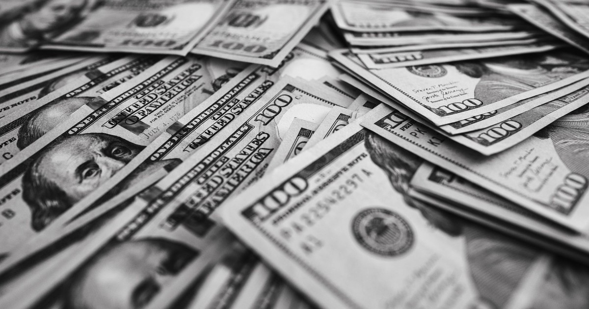 Monochrome image of scattered US hundred dollar bills representing wealth and prosperity.