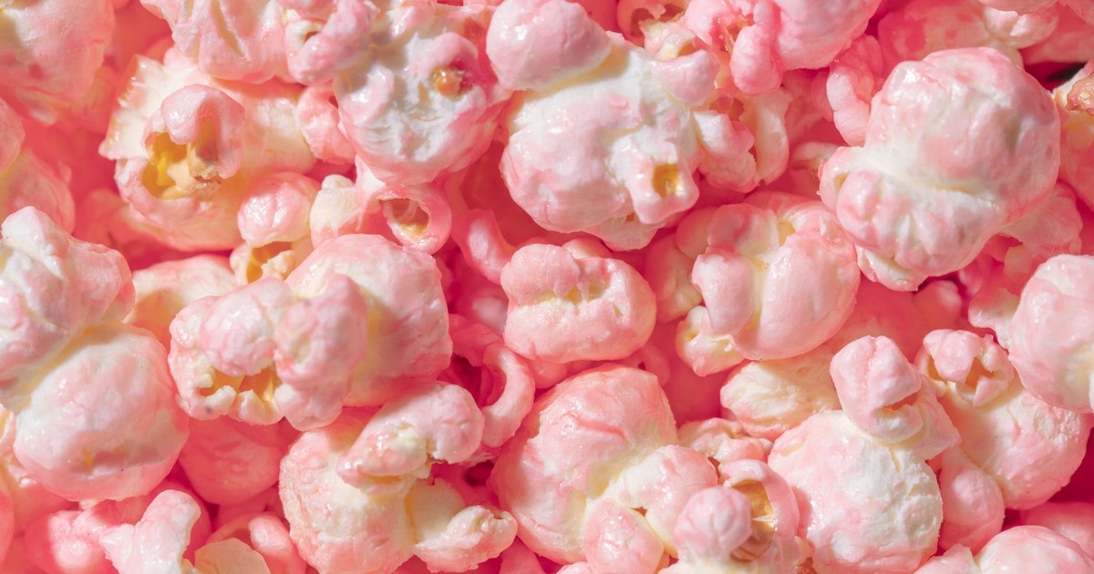 Vibrant close-up of pink candy coated popcorn, perfect for sweet snack themes.