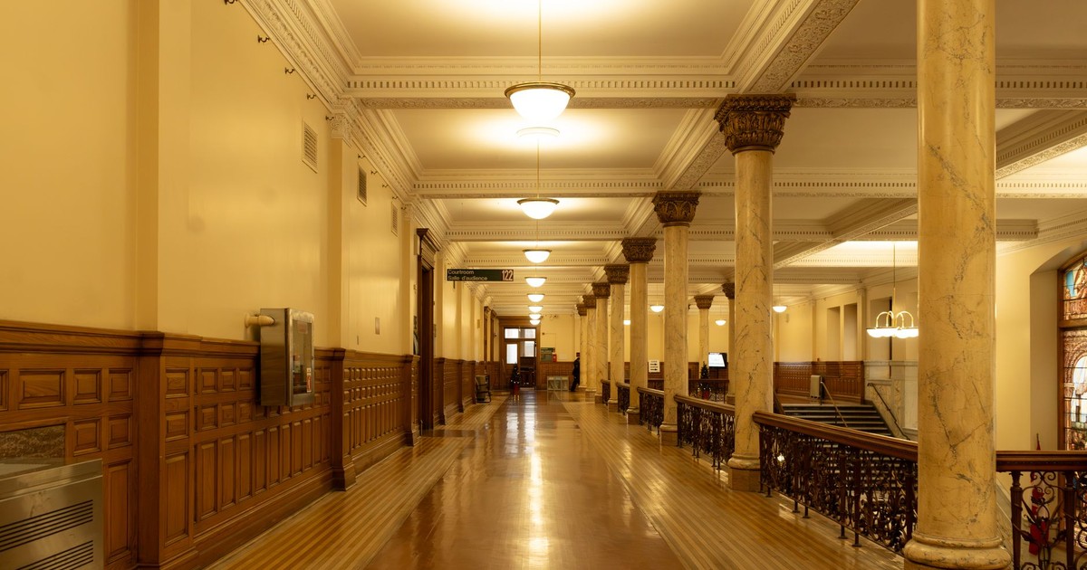 Spacious corridor with elegant marble columns and vintage lighting in a historic building.
