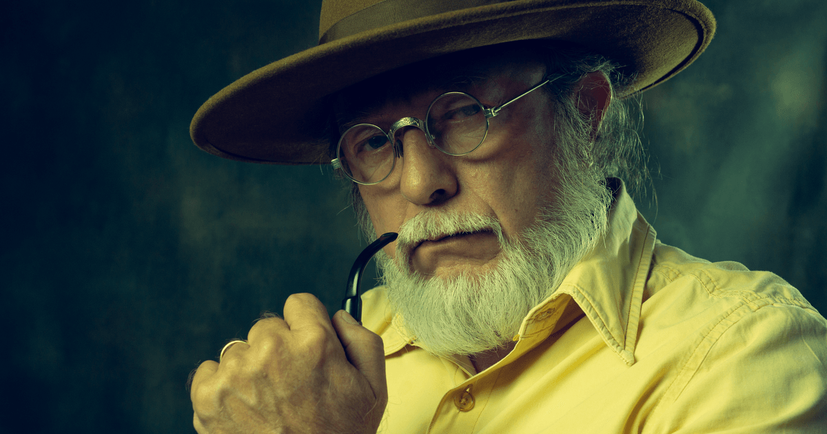 Close-up portrait of a senior man wearing a hat, glasses, and smoking a pipe, exuding wisdom and contemplation.