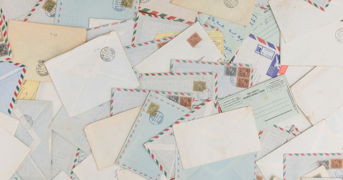 A collection of vintage airmail envelopes and postcards scattered with stamps.