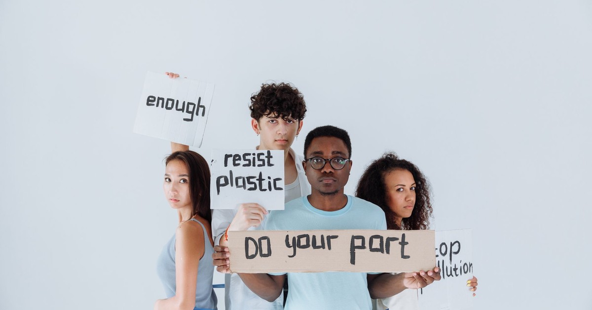 Diverse group of young activists holding signs at an environmental protest, conveying messages of change.