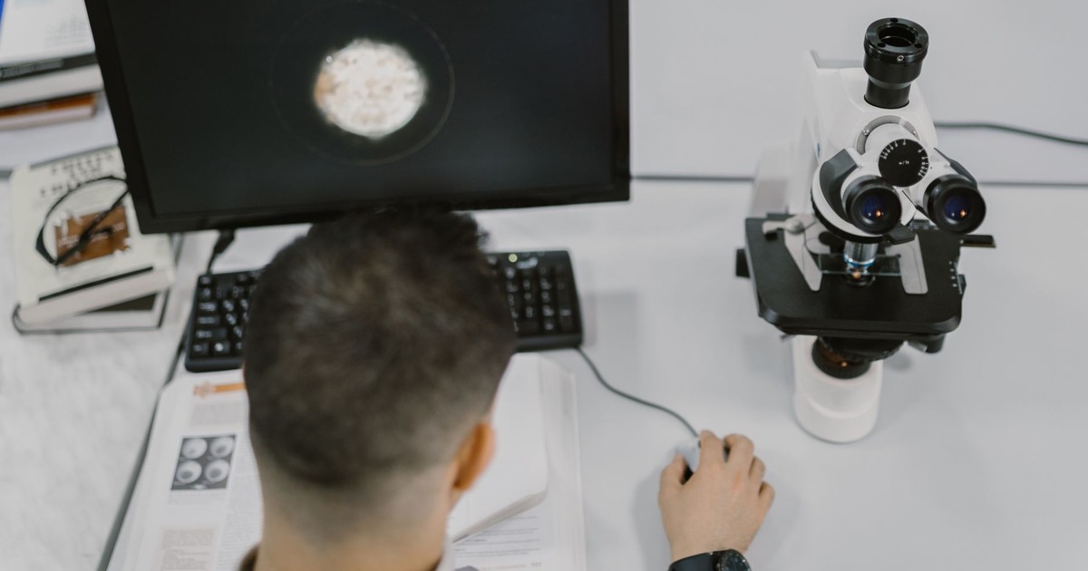 Scientist working with a microscope in a modern laboratory setup.
