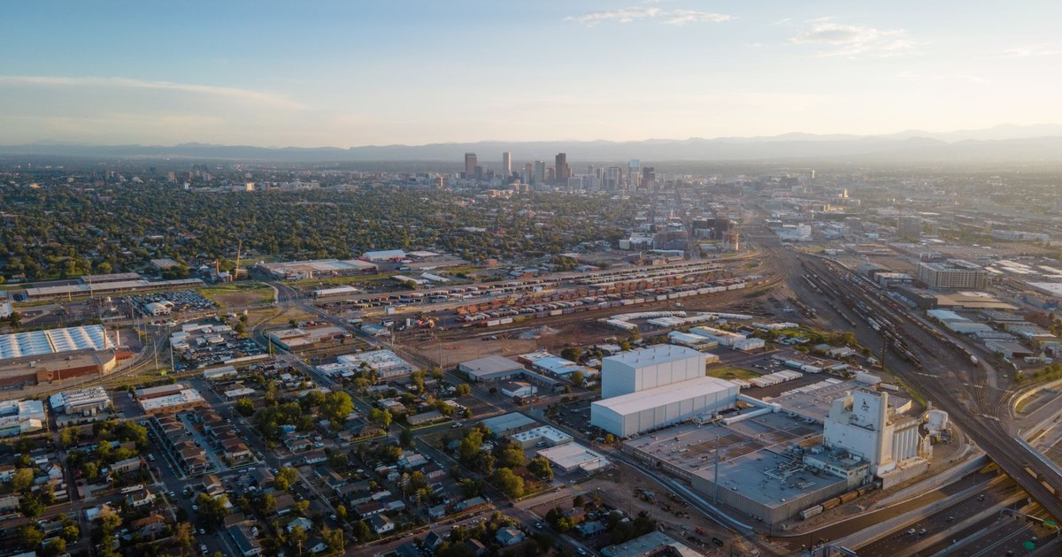 Stunning aerial view of Denver cityscape with urban sprawl and distant skyline at dusk.