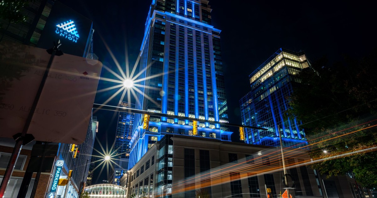 A vibrant cityscape at night showcasing brightly illuminated skyscrapers and dynamic light trails.