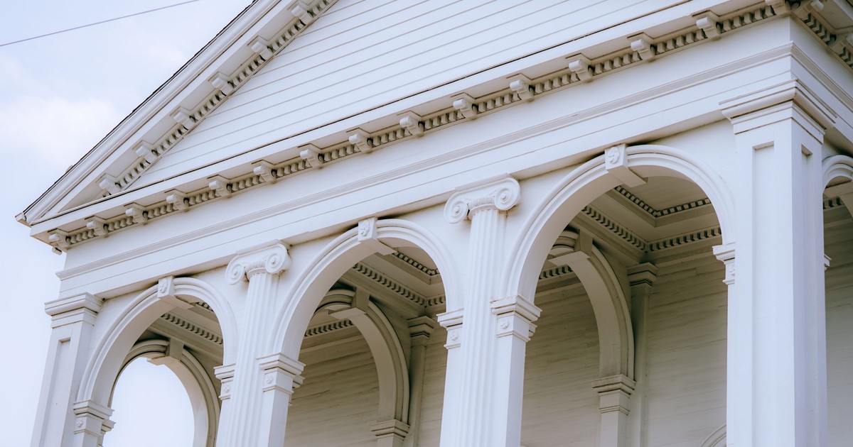 A close-up view of a neoclassical building facade featuring detailed arches and columns.