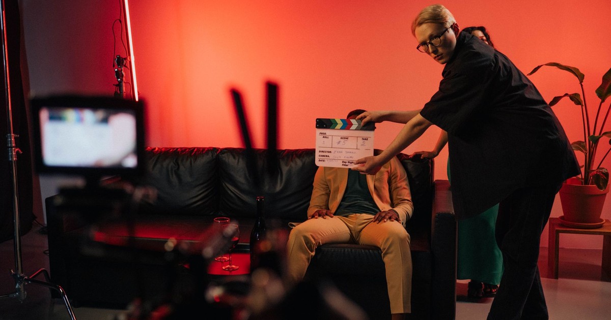 Film production team setting up a scene on an indoor set with dramatic lighting.