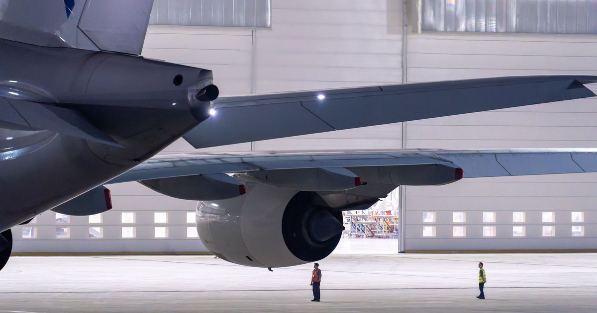 View of maintenance crew inspecting an airplane in a hangar.