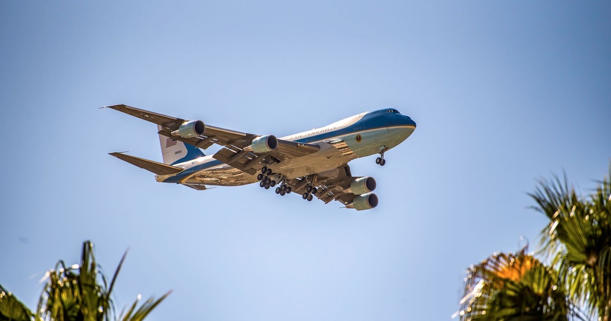 Presidential aircraft Air Force One flying above palm trees in Palm Springs, California.