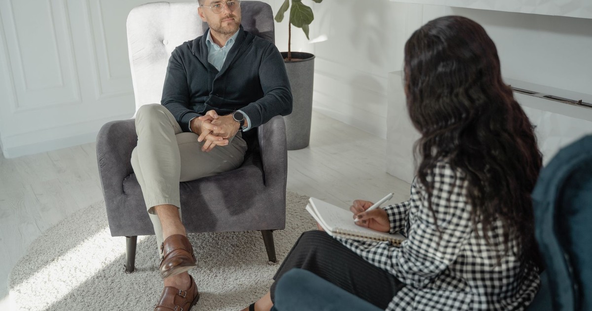 A therapist and client in a modern office setting, engaged in a counseling session.