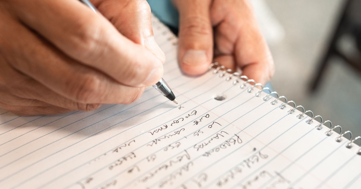 Detailed image of hands writing in a notebook, emphasizing creativity and organization.