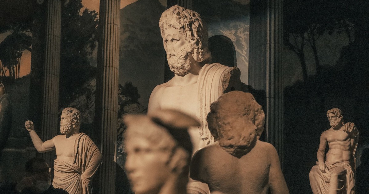 A collection of ancient sculptures displayed in a dimly lit museum setting.