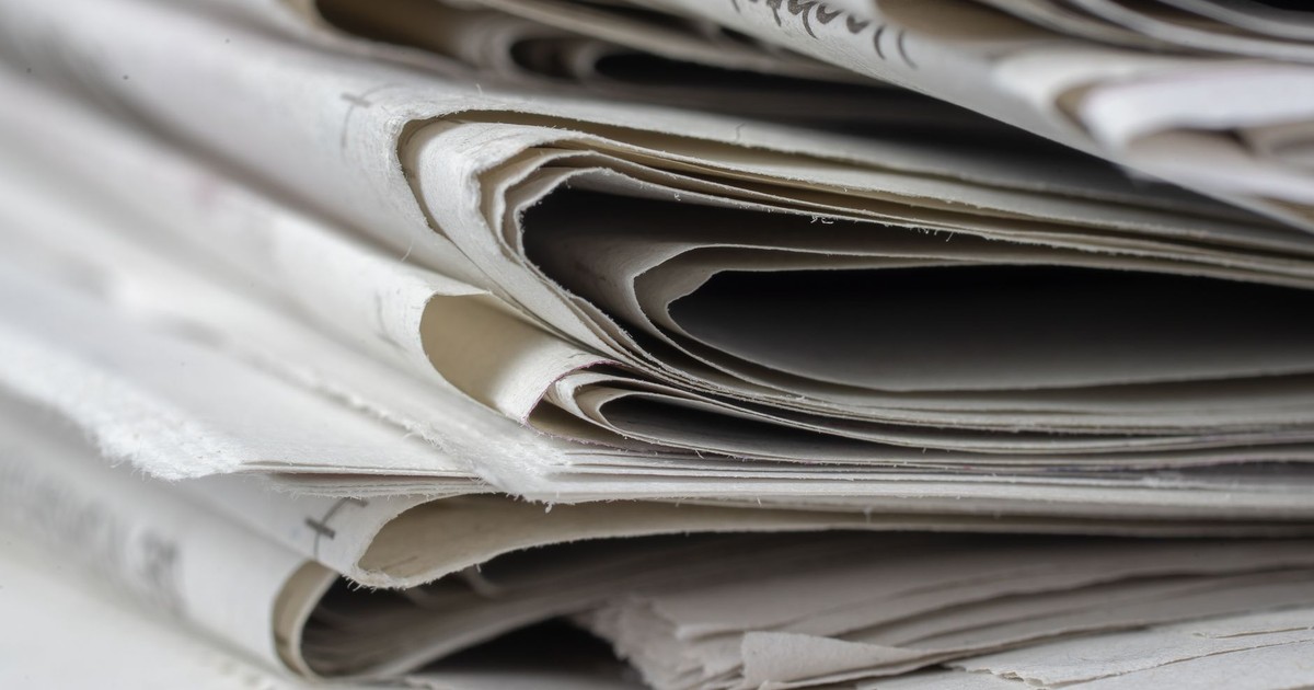 A detailed close-up view of stacked newspapers, highlighting textures and layers.