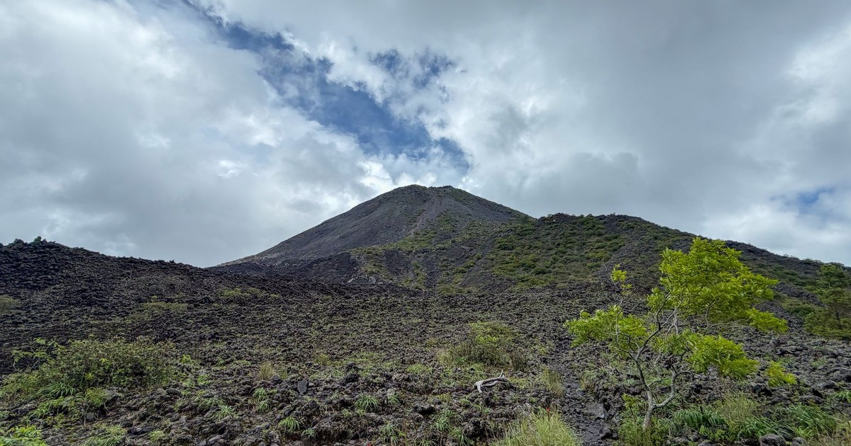 A breathtaking view of the lush landscape and volcano under a dramatic cloudy sky in Santa Ana, El Salvador.