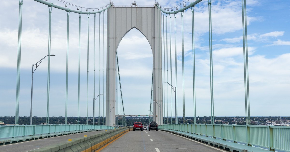 Suspension bridge in Newport, RI with vehicles on a sunny day.