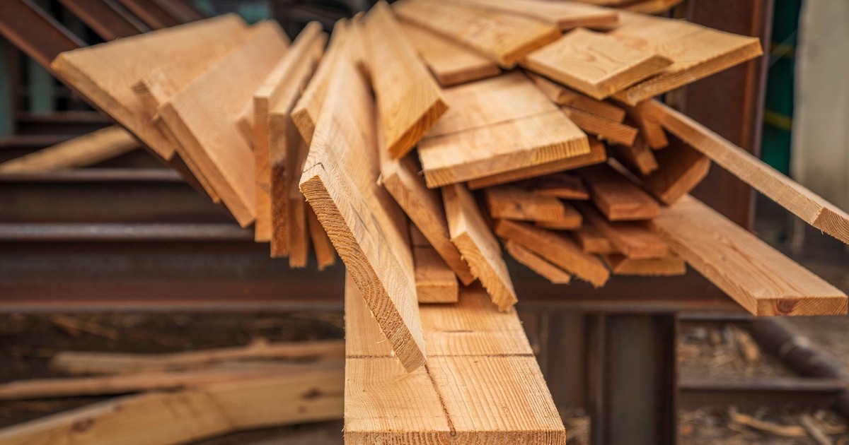 A close-up view of stacked hardwood lumber in a carpentry workshop, showcasing woodworking materials.