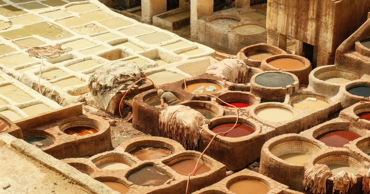 Vibrant view of a traditional tannery in Fes, Morocco, showcasing colorful dye vats and hides tanning in the sunlight.