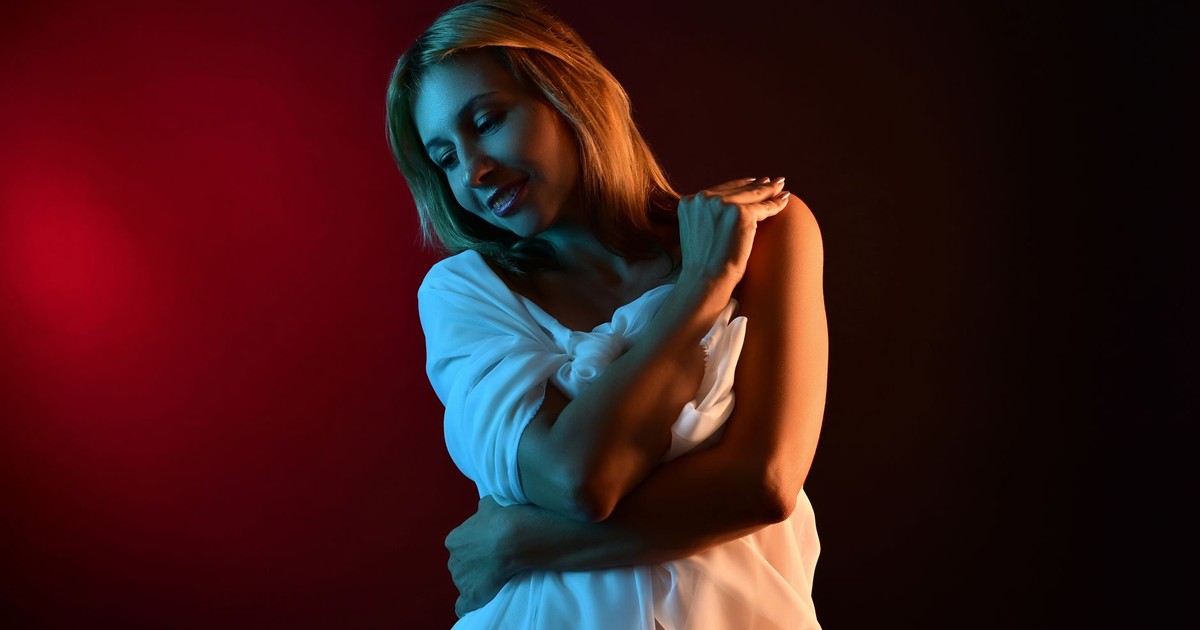 Stylish portrait of a woman in soft fabric with artistic lighting, exuding elegance and emotion.