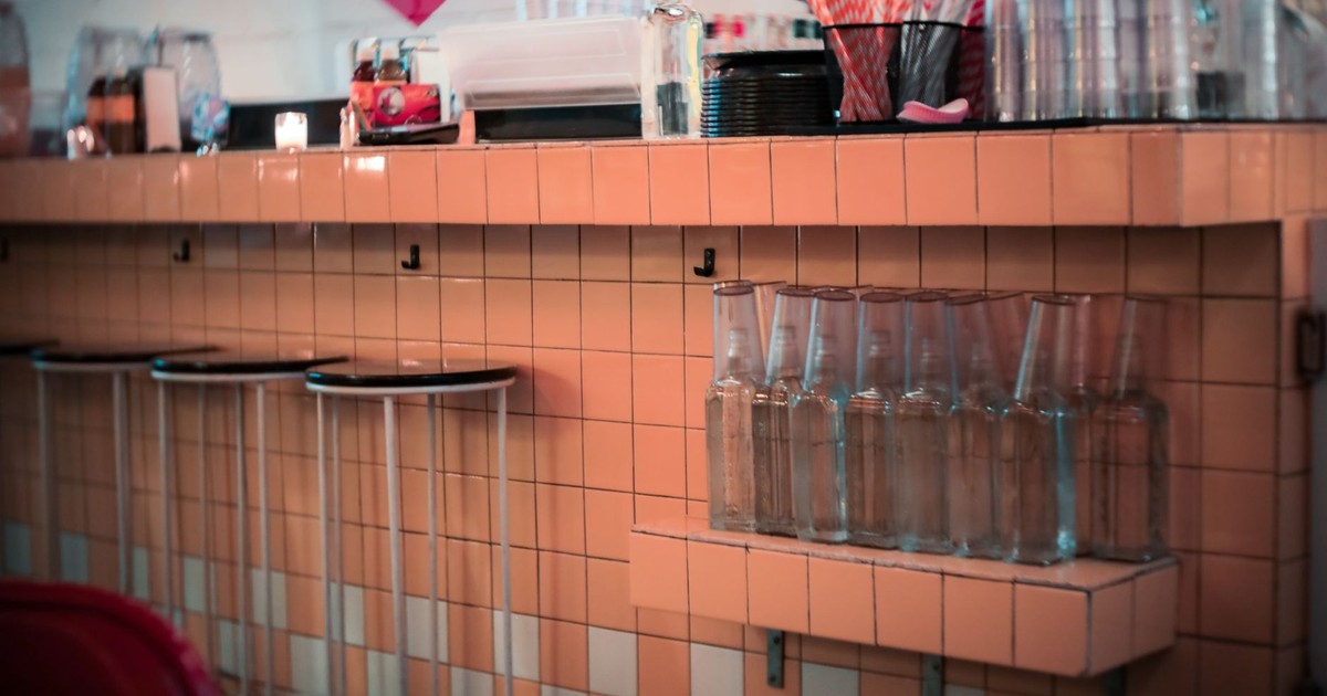 Vintage-style diner counter in a New York restaurant, showcasing classic tiles and bar stools.
