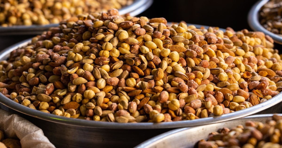 A close-up of assorted roasted nuts in stainless steel bowls, ideal for healthy snacking.