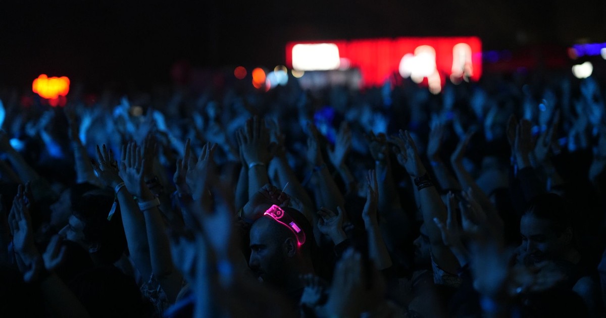 A lively concert scene with a crowd of people enjoying the music at night.