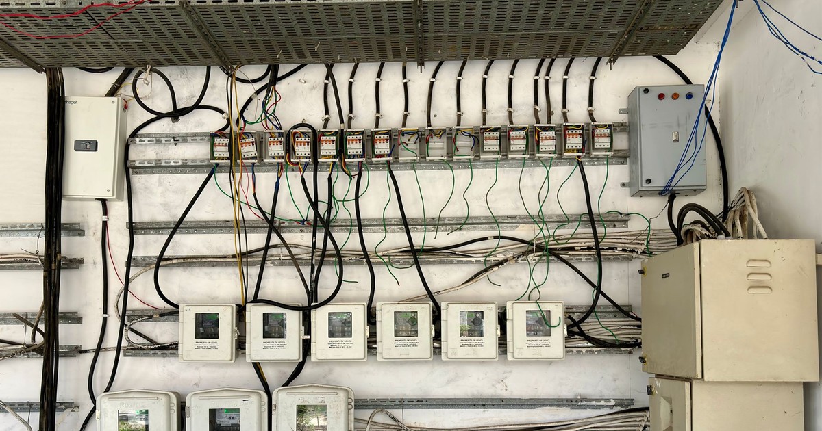Complex network of electrical wiring and control panels in an industrial setting.