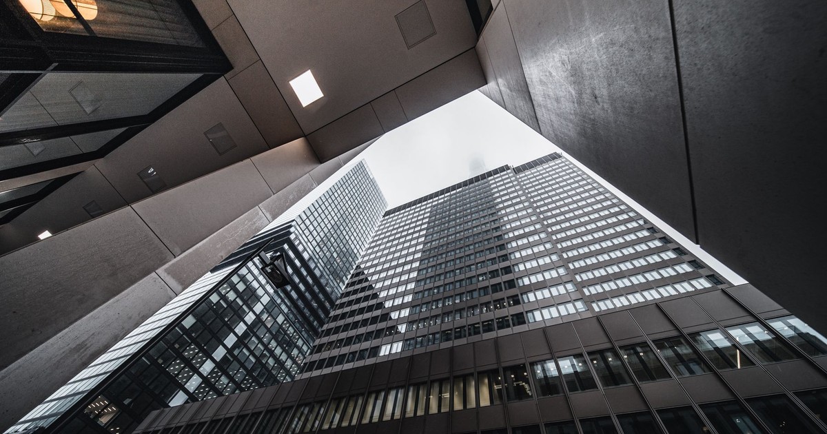 Low-angle view of modern skyscrapers with glass facades in an urban environment.