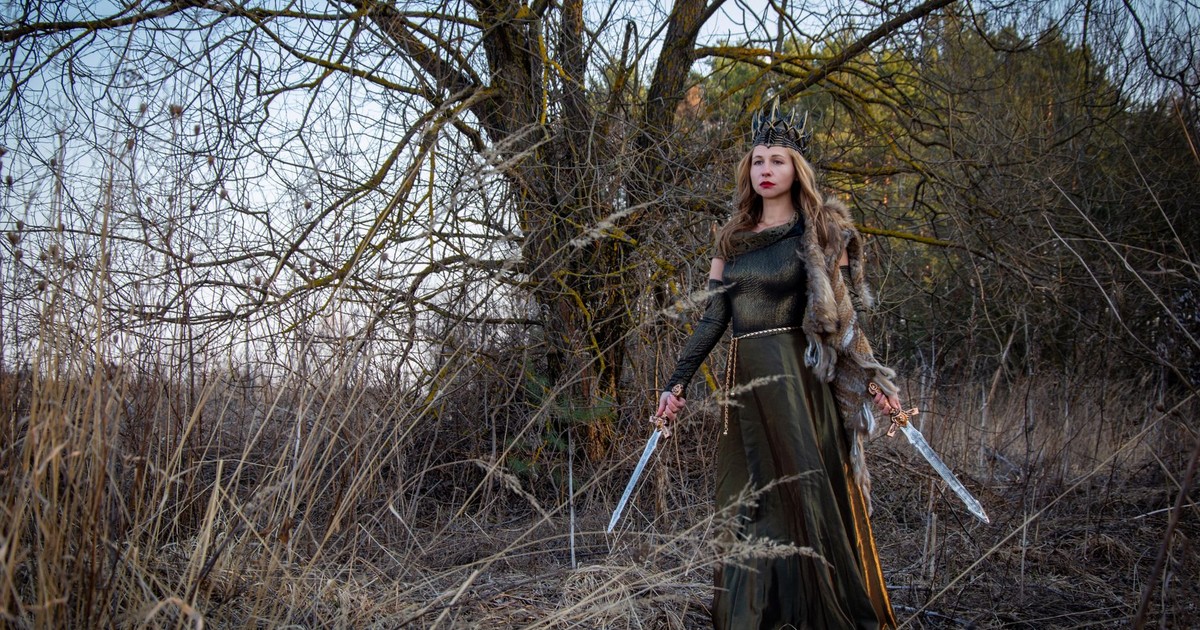 A regal woman with swords stands in a mystical forest, exuding power and elegance.