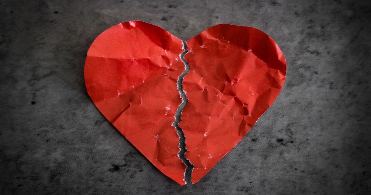 A torn red paper heart symbolizing heartbreak and lost romance.