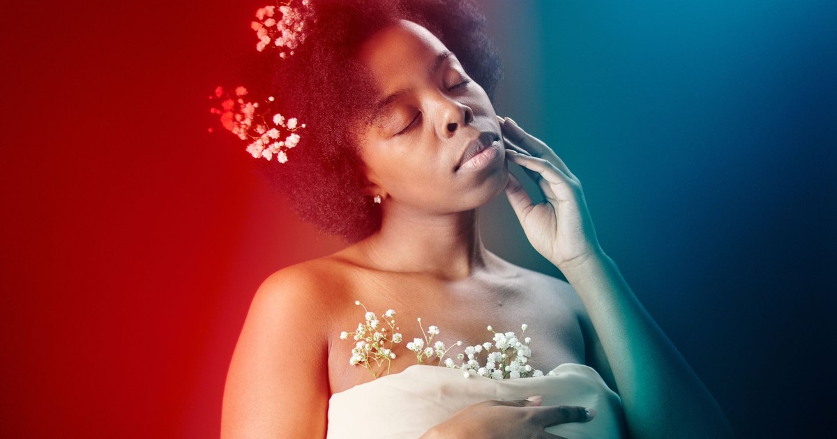 A serene portrait of a woman with flowers in her hair, highlighted by colorful lighting, exuding elegance and tranquility.