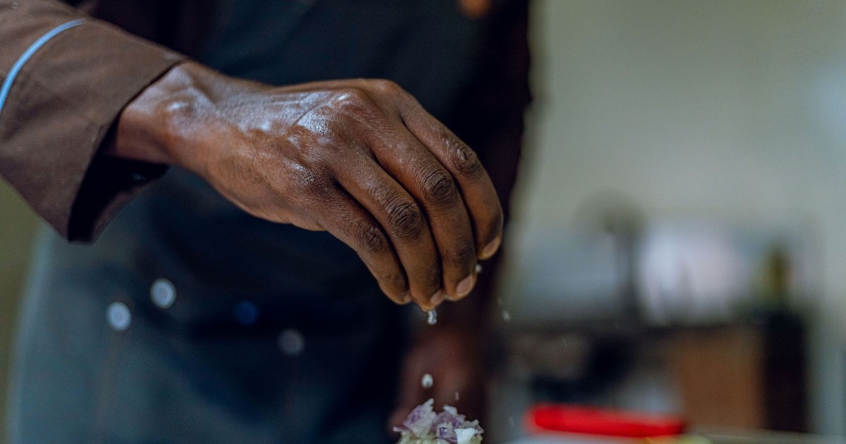 Close-up of a chef seasoning an avocado dish, adding a touch of culinary art to gourmet cooking.
