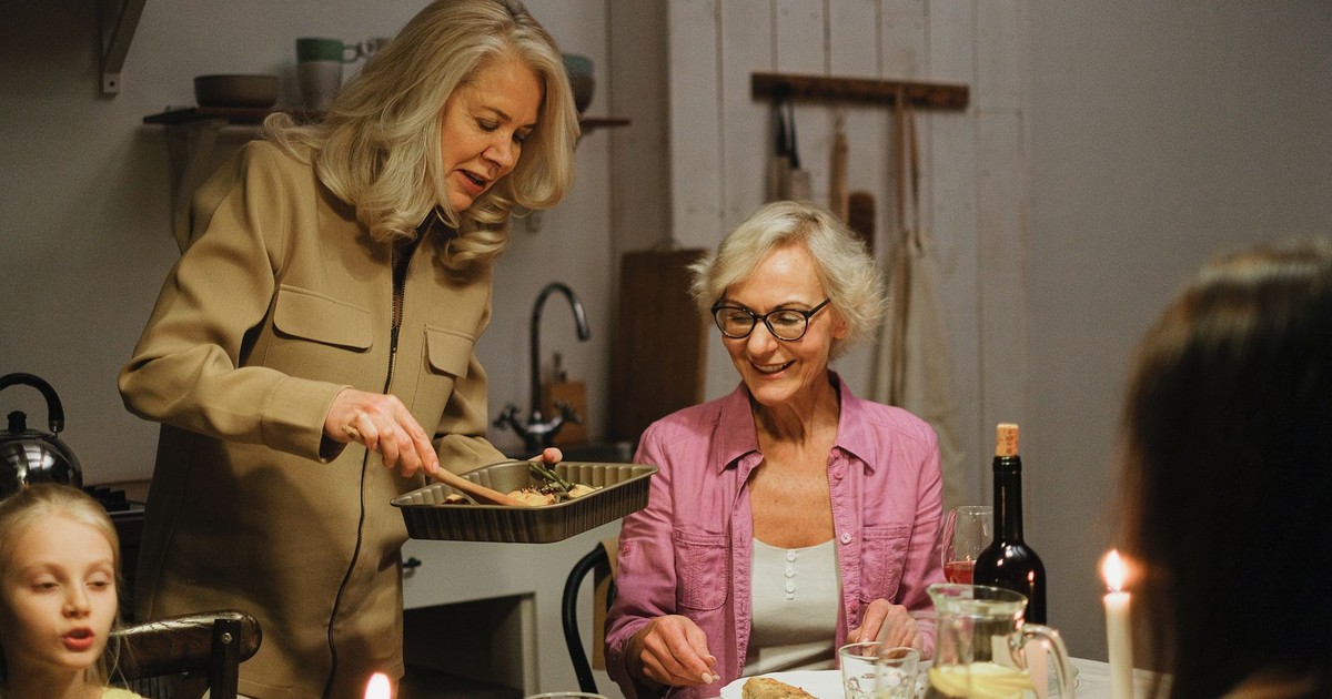 A family enjoys dinner together with warmth and conversation in a cozy indoor kitchen.