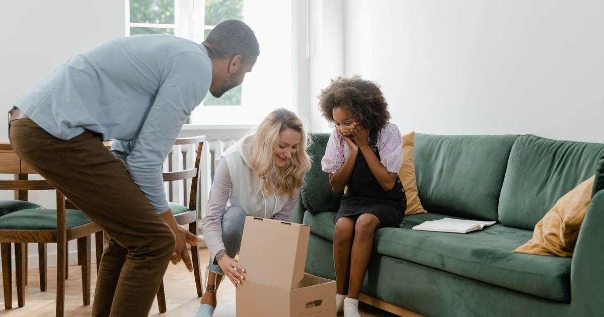 A diverse family unwraps a surprise gift in their cozy living room, capturing happiness and togetherness.