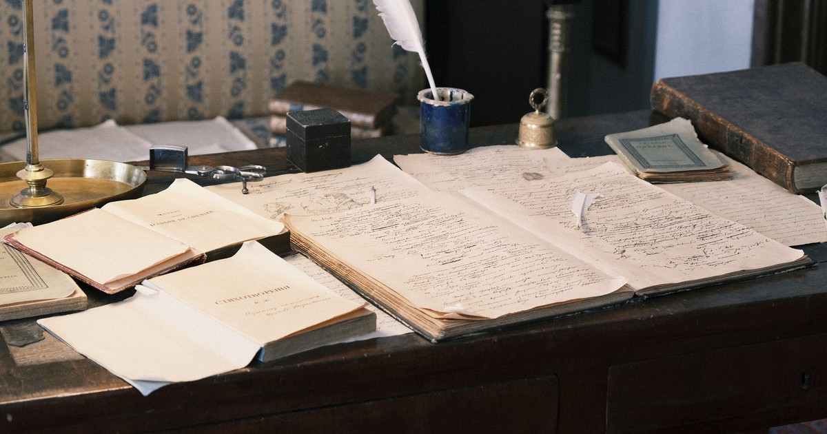 Cozy study with vintage desk, open books, and quill for a classic literary feel.