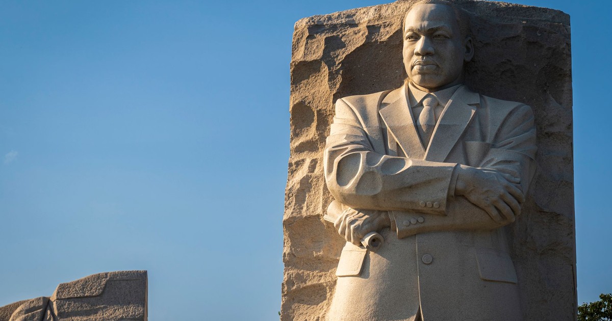 Sculpture of Martin Luther King Jr at the Washington DC Memorial against a blue sky.