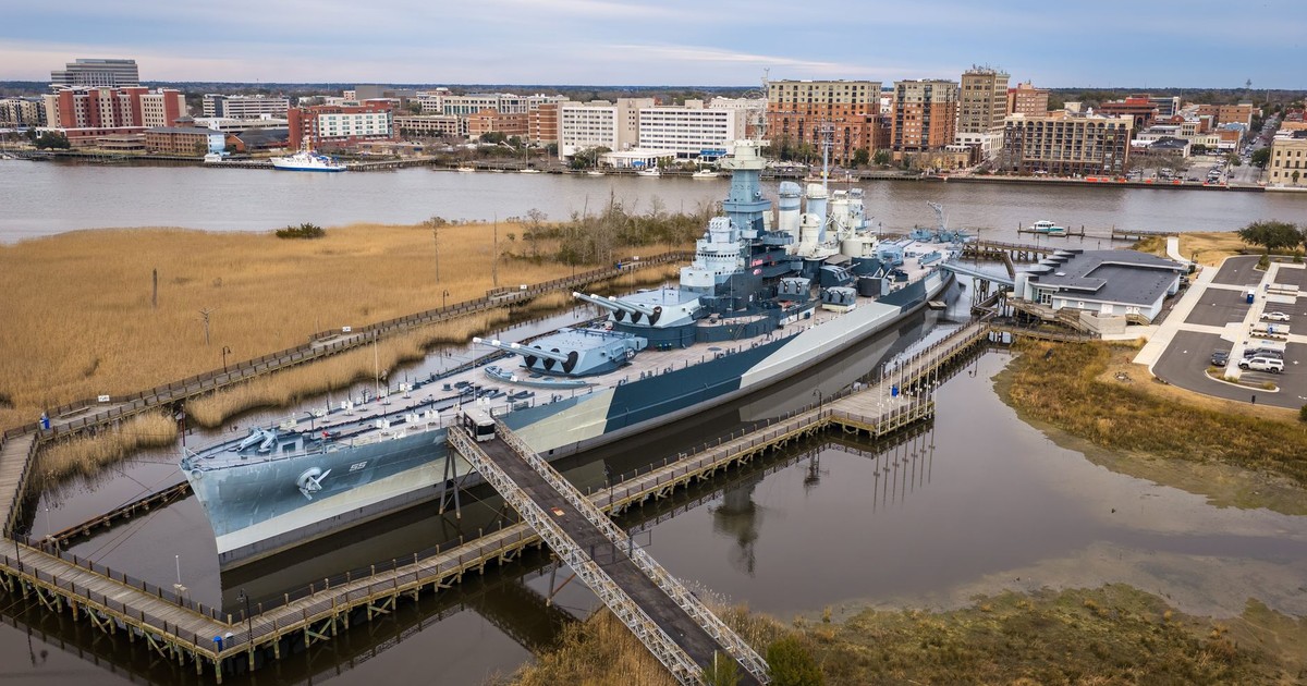 Aerial view of the USS North Carolina in Wilmington, NC with cityscape.