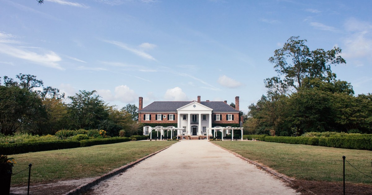 Picturesque view of Boone Hall Plantation's historic mansion in South Carolina under a blue sky.